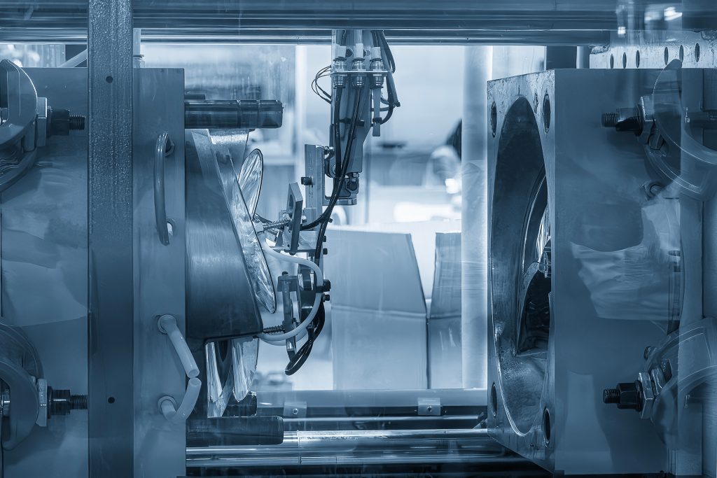 Máquinas industriais com componentes robóticos, apresentando superfícies metálicas e várias peças mecânicas. O ambiente parece ser uma fábrica ou oficina.